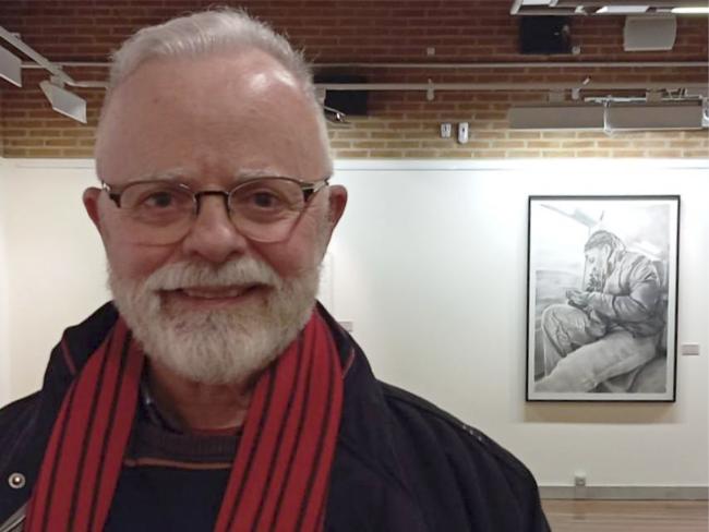 Juan Ramón Luque Ávalos, posando con su dibujo “Dos mundos” en la exposición