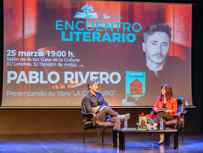 Momento de la conversación del escritor con la periodista del  Ayuntamiento de Torrejón, Montse García